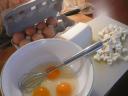 Klop de eieren los en meng met de blokjes geitenkaas
