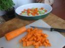 Snijd de gewassen groenten in kleine stukjes en doe ze in een ingevette ovenschaal