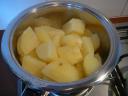Aardappels schillen, in stukken snijden en gaar koken.