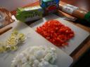 Hak de uien fijn en snijd de paprika in blokjes. Snijd ook de andere groente.