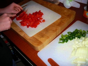 Snipper de ui, maak de paprika en pepers schoon en snijd ze in stukjes